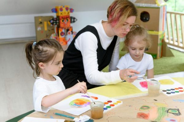 Young children participating in hands-on learning activities that develop fine motor skills and creativity in the Toddler & Preschool program